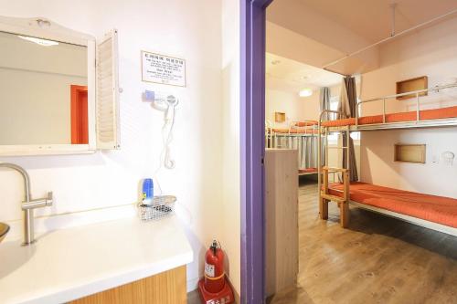 a bathroom with a sink and a bedroom with a bunk bed at SUM Guesthouse Jeju Airport in Jeju