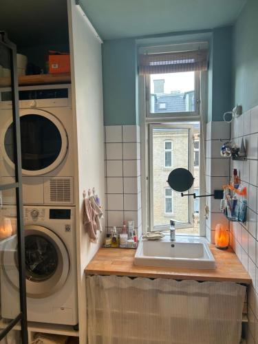 a kitchen with a sink and a washing machine at Bright apartment in central Copenhagen in Copenhagen