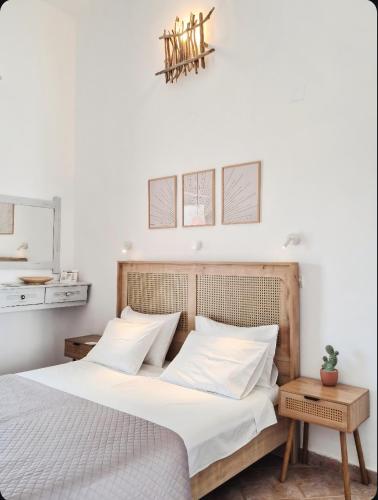 a bedroom with a white bed with white pillows at Voula Accommodation in Agios Georgios