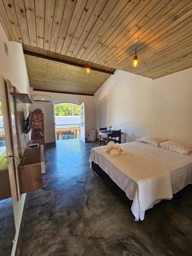 a bedroom with a large bed and a wooden ceiling at San Sebastian Taipu de Fora in Marau