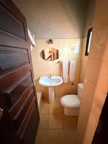 a bathroom with a sink and a toilet and a mirror at Executive Manica Hotel in Chimoio