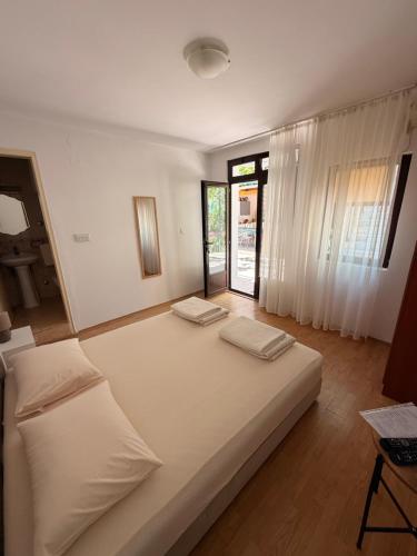 a large bed in a room with a window at Apartments Marina in Bečići