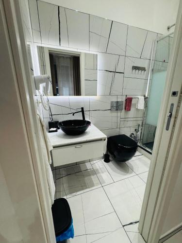 a bathroom with a sink and a mirror and a toilet at Laura Rooms in La Spezia