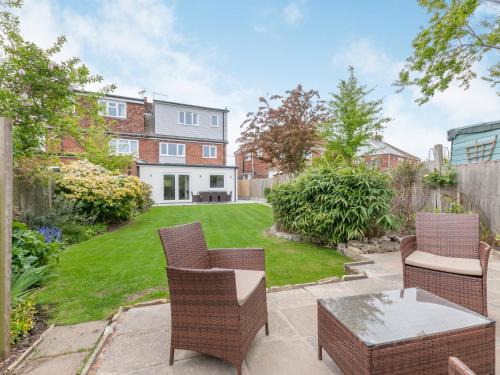 a patio with chairs and a table and a yard at Whit's End House in Whitstable