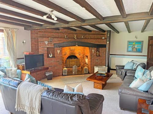 a living room with couches and a brick fireplace at Lambourne House - Ukc2831 in Skegness