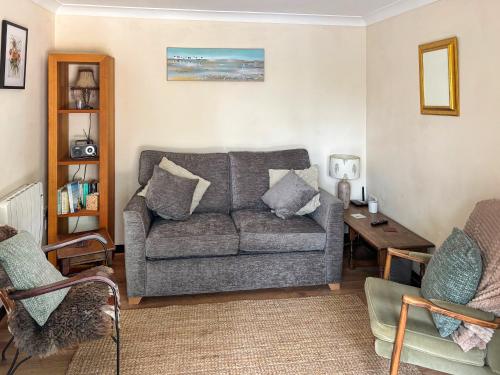 a living room with a couch and a table at Fuschia Chalet in Framlingham