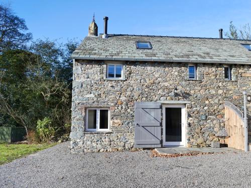 a stone house with a door and a garage at Tarn Rigg Cottage - Uk1368 in Keswick