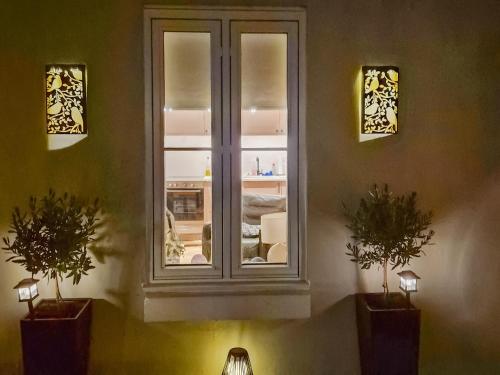 a window in a room with two potted plants at The Colleys in Lechlade