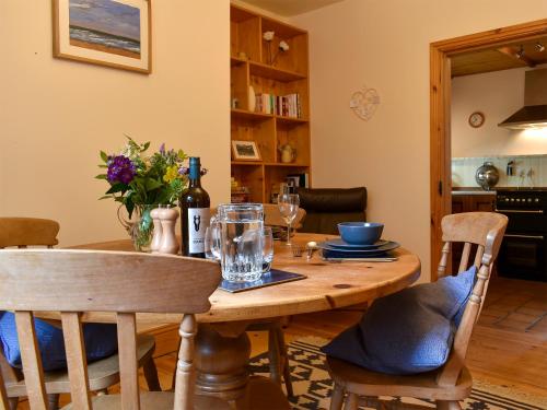 a dining room table with a bottle of wine on it at Bell Hill Cottage in Lindale