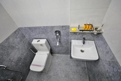 a bathroom with a sink and a toilet at Hotel Ceasta US Consulate Hyderabad, Gachibowli in Gundipet