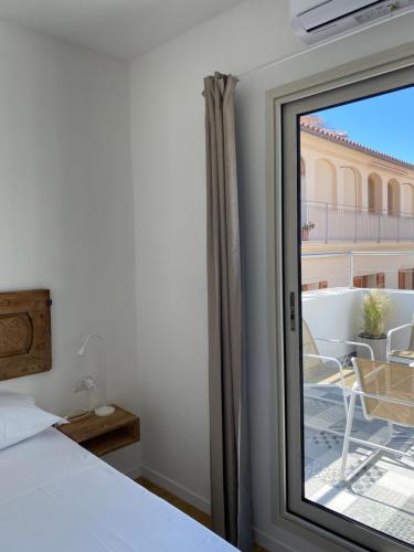 a bedroom with a bed and a view of a balcony at azul rooms & suites in Olbia