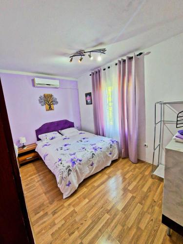 a bedroom with a purple bed and a wooden floor at Eco Bay Montenegro in Donji Morinj