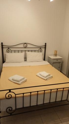 a bedroom with a bed with two towels on it at Kelenis Apartments in Karterados