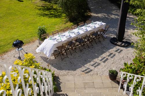 a long table with chairs and plates on it at Historisch herenhuis voor 12 personen met volledig ommuurde tuin in Oudenaarde