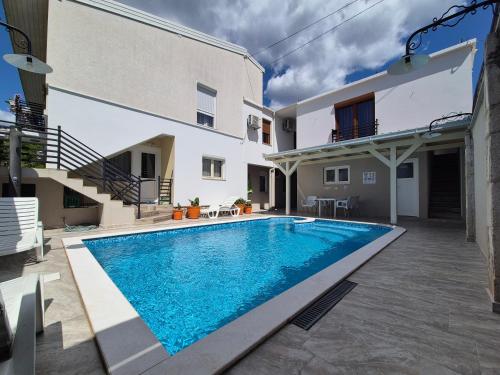 a swimming pool in front of a house at Pansion & Apartments MOST Blagaj in Blagaj
