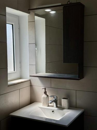 a bathroom with a sink and a mirror at Villa Alonia House in Kallithéa