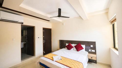 a bedroom with a bed with red pillows at Tara inn in Alwaye