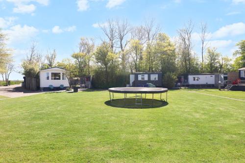 a picnic table in the middle of a grass field at Camping Oudesluis in Oudesluis