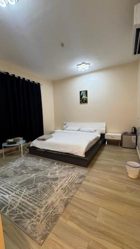 ein Schlafzimmer mit einem Bett und einem Teppich in der Unterkunft Arlo Oman in Firq