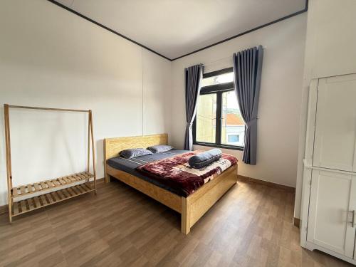 a bedroom with a bed and a window at Mây HomeStay in Da Lat