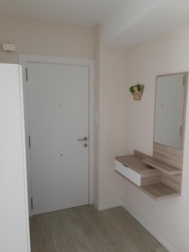 a white room with a door and a mirror at Piso Gallega in Finisterre