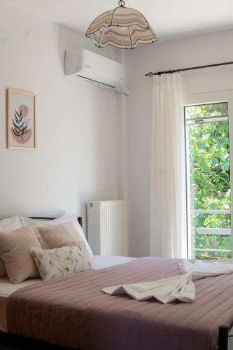 a bedroom with a large bed with a window at Aura 2 Apartment in Vathý