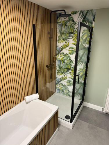 a bathroom with a shower and a bath tub at Harbour View Holiday Apartment in Donaghadee