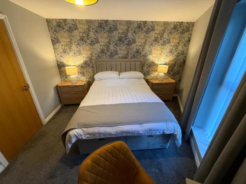a bedroom with a bed with two night stands and two lamps at Harbour View Holiday Apartment in Donaghadee