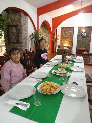 two children sitting at a table with plates of food at Ragas in Palma Sola