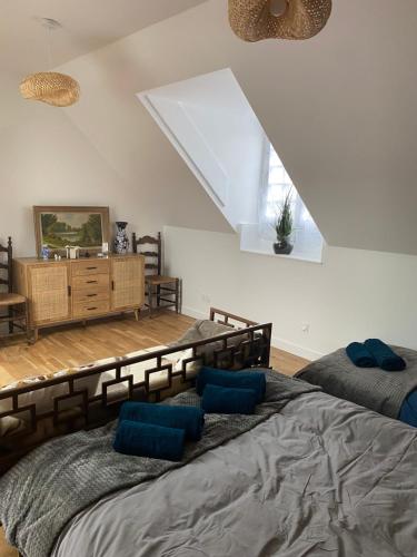 a bedroom with a large bed with blue pillows at Charmant maison in Pontorson