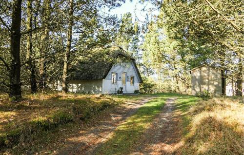 a small white house in the middle of a dirt road at Holiday Home Narssagsvej in Rømø