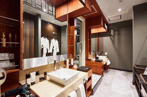 a bathroom with a sink and a large mirror at Hotel PALM GATE in Fukuoka