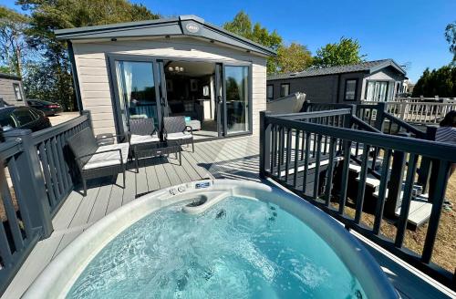 a hot tub on the deck of a house at Exclusive Lakeside Holiday Lodge with Hot tub and Private Fishing Peg at Tattershall Lakes in Tattershall