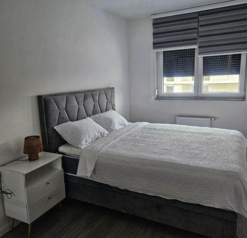 a bedroom with a large bed and two windows at Nora in Žepče