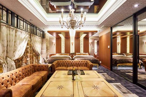 a room with couches and a table and a chandelier at Hotel PALM GATE in Fukuoka