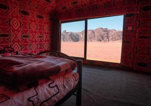 a bedroom with a bed and a view of the desert at Rum Sky Experiences in Wadi Rum