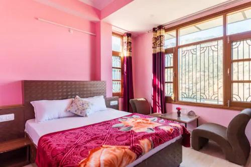 a bedroom with a bed with pink walls and windows at Indu BNB Shimla in Shimla
