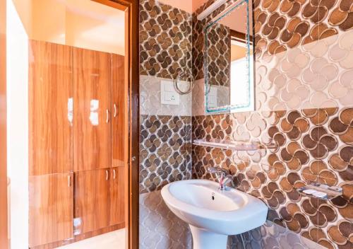 a bathroom with a sink and a mirror at Indu BNB Shimla in Shimla