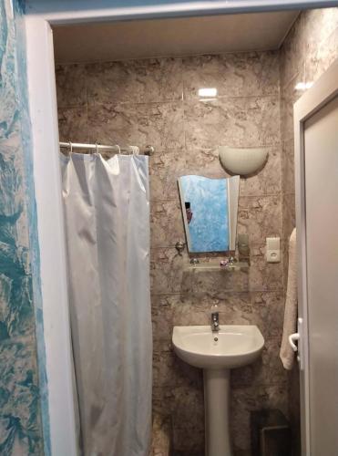 a bathroom with a sink and a shower curtain at Hotel Pagio in Chaisubani