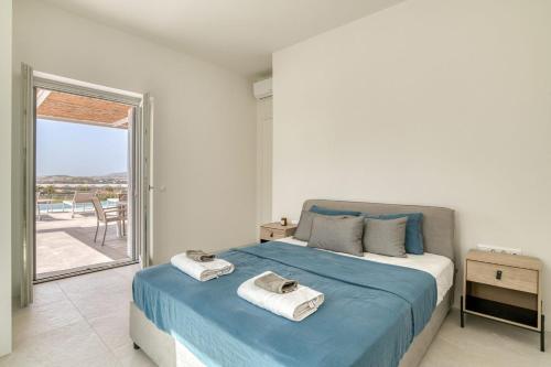 a bedroom with a bed with towels on it at Villa Ariadni Paros in Isterni