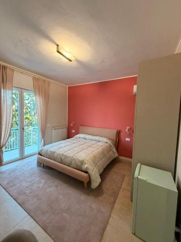 a bedroom with a bed and a red wall at VillaVenere in Rossano