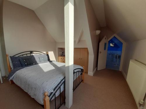 a bedroom with a bed and a blue door at Shellsborough Penthouse in Woolacombe
