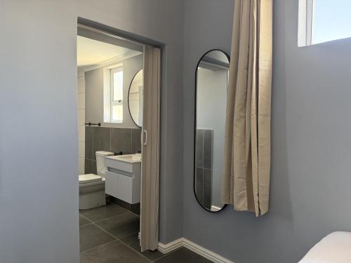 a bathroom with a mirror and a sink at Evangeline House in Cape Town
