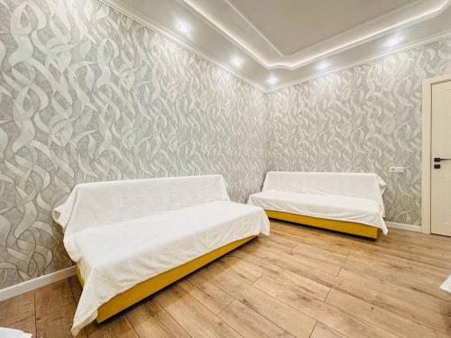 two beds in a room with a wall at Гостевой Хаб у Сайрана 8 спальных мест у автовокзала in Almaty