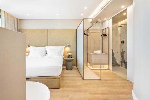 a hotel room with a bed and a glass door at Castelo Suites Hotel in Albufeira