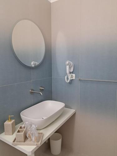 a bathroom with a white sink and a mirror at Venti Magici Rooms in Peschici