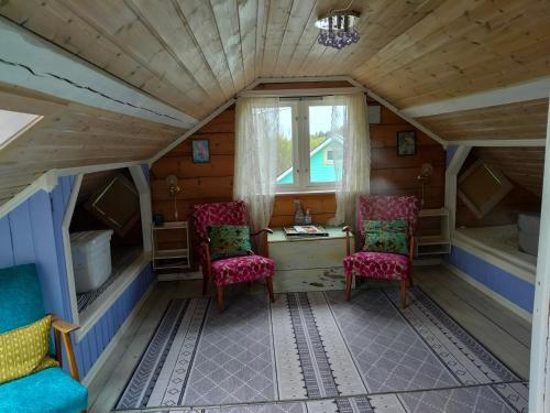 a room in a tiny house with two chairs and a desk at Høgberget Loft with 3 bedrooms and private bathroom in Skotten
