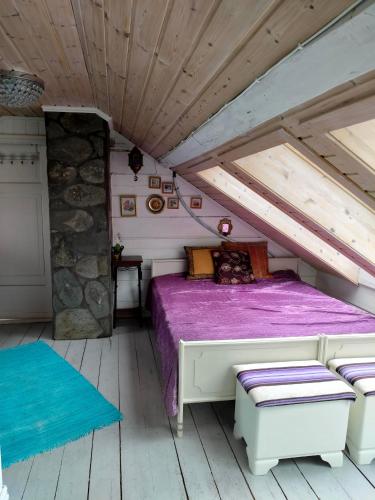a bedroom with a bed in a attic at Høgberget Loft with 3 bedrooms and private bathroom in Skotten