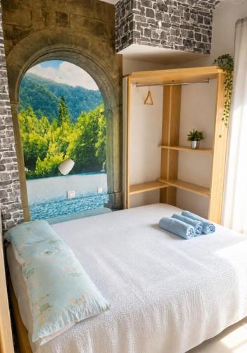 a bedroom with a bed and a window with a view at Pensión Jordi Tossa de Mar in Tossa de Mar