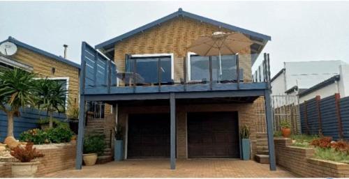 a house with a balcony on top of it at Hartmel Sea Deck in Hartenbos